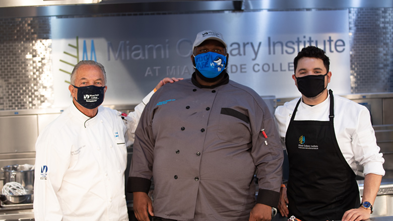 Culinary program students and staff pose by kitchen