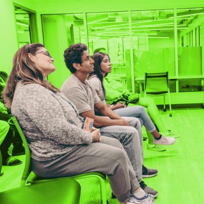 Three young professionals in a waiting room, the picture has a green background