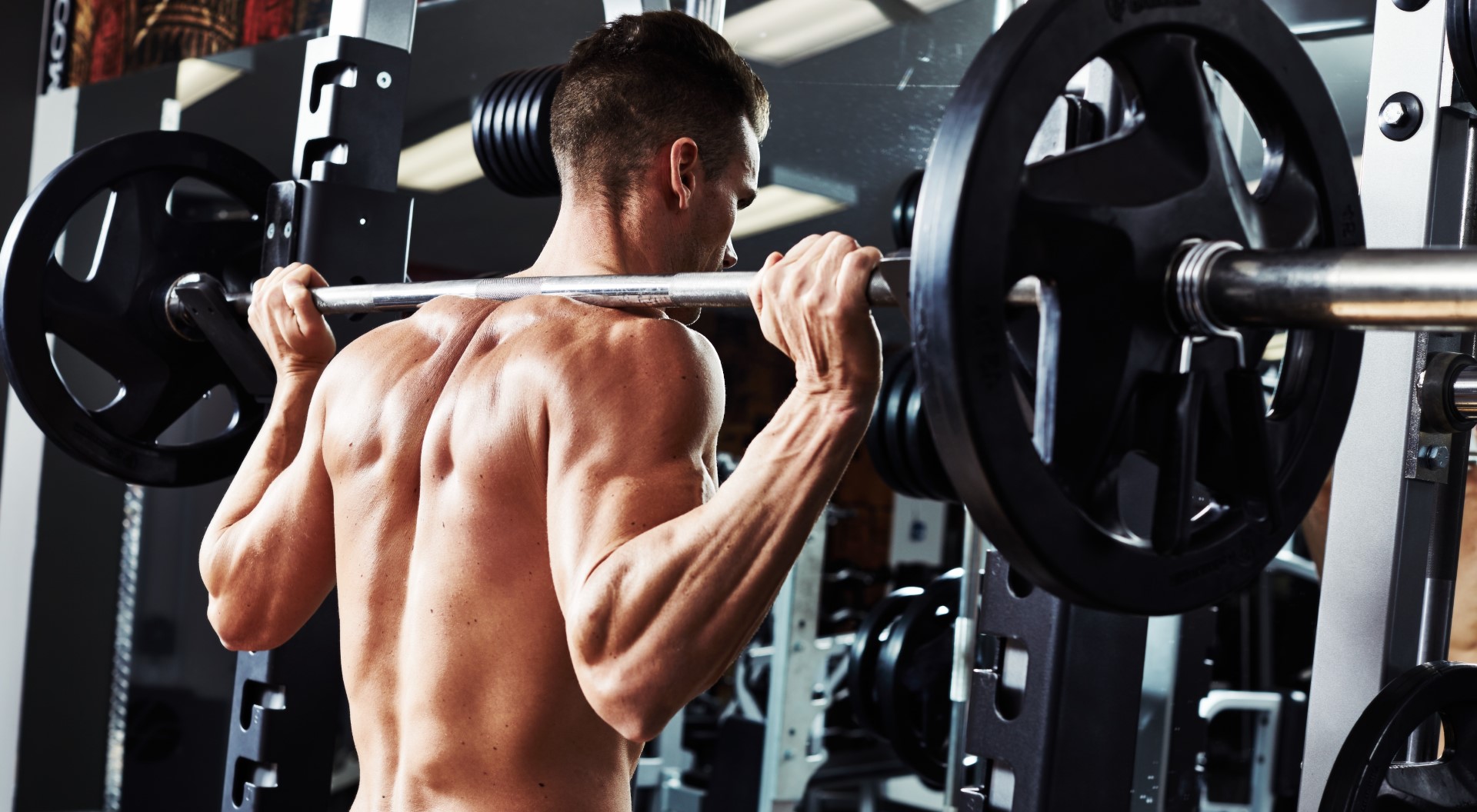 A man in a gym hefts a large amount of weights