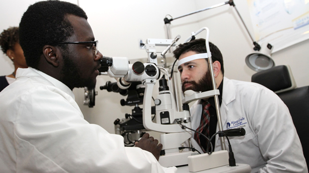 Two students from optical program practice an examination