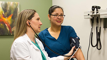 Medical professional measuring blood pressure on student