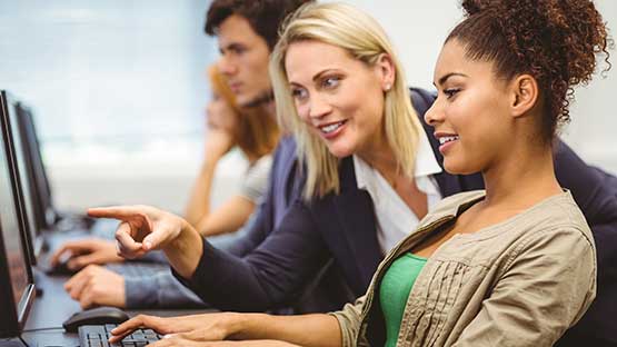 Professor teaching student in front of computer