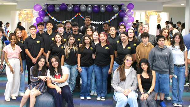 A big group of MDC students with a background of balloons