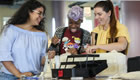 Three students work on a sewing project together